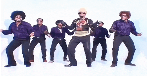a group of men are dancing and one of them is wearing a shirt that says ' fuel ' on it