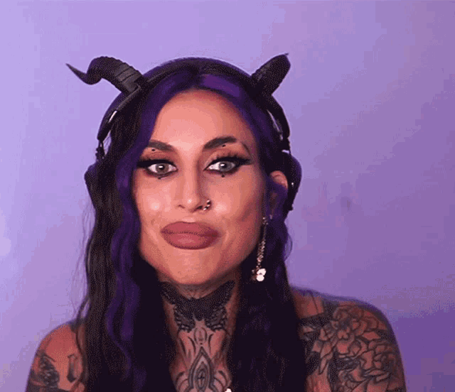 a woman with purple hair wearing horns and headphones