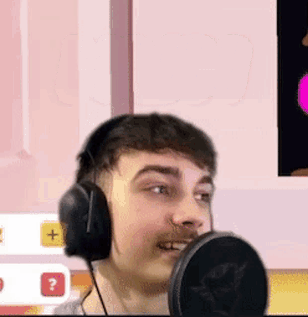 a man wearing headphones and a microphone is smiling .