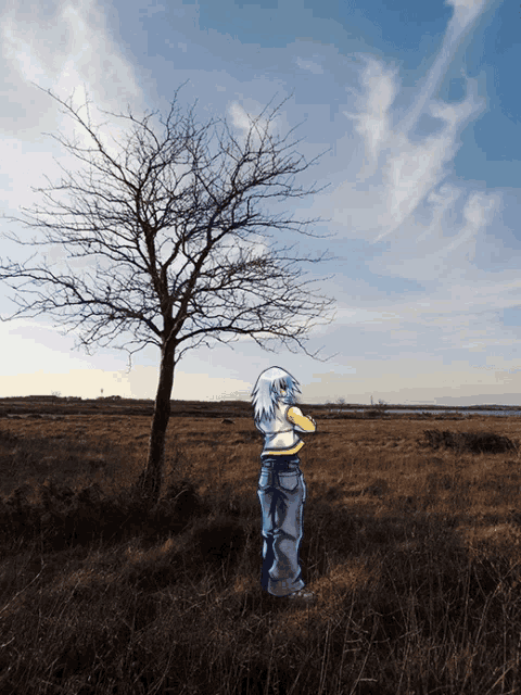 a person standing in a field with a tree without leaves in the background