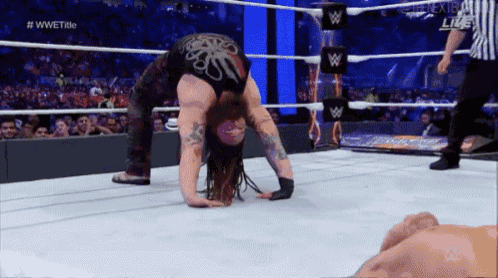a wrestler is doing a handstand in the ring