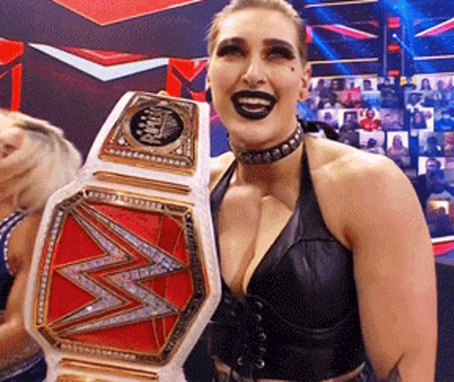 a woman is holding a wwe championship belt