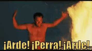 a shirtless man stands in front of a fire with the words arde ! iperra ! arde !