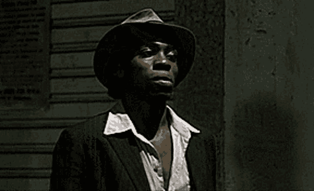 a man with his arms outstretched is standing in front of a wooden wall .