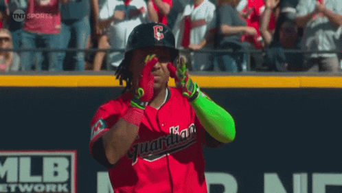a baseball player wearing a red uniform with the word guardians on the front