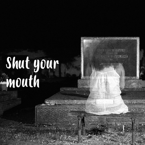 a black and white photo of a woman sitting in front of a grave with the words shut your mouth below her