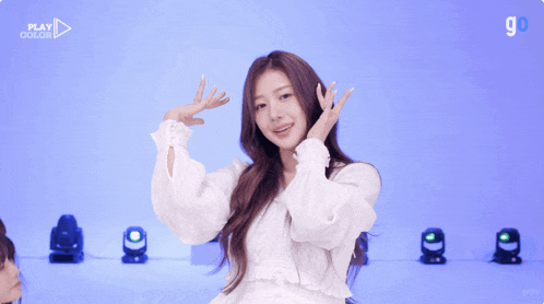 a girl in a white dress is dancing in front of a blue background with the number 9 on it