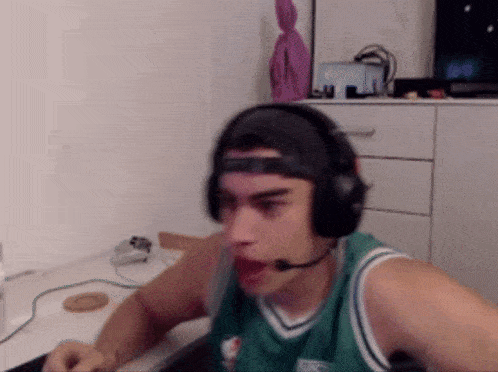 a man wearing headphones and a boston celtics shirt