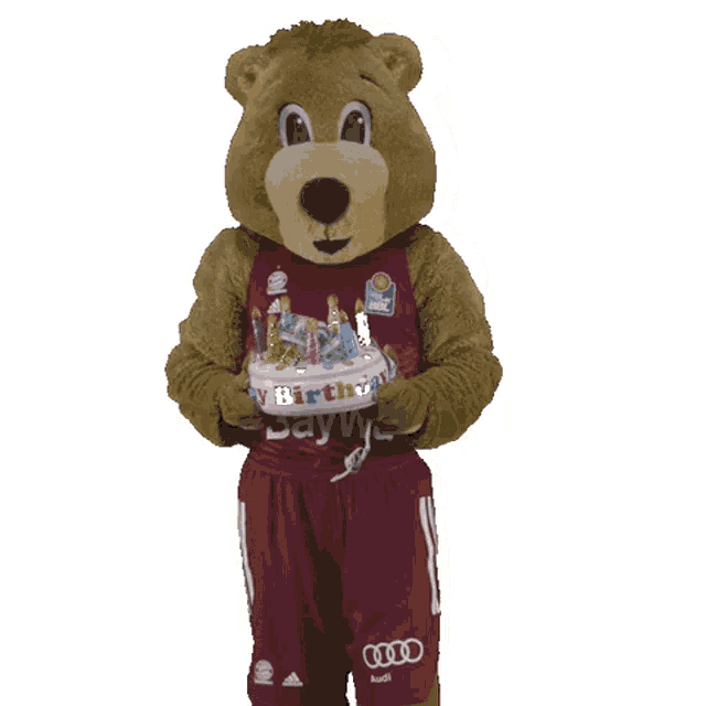 a mascot wearing a red shirt that says baywa holds a birthday cake