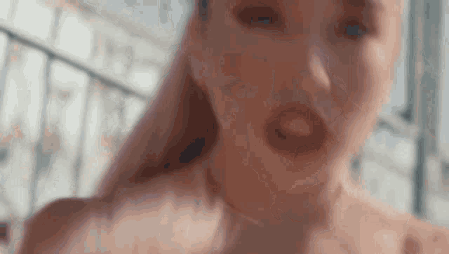 a close up of a woman 's face with red lips and a blurred background .