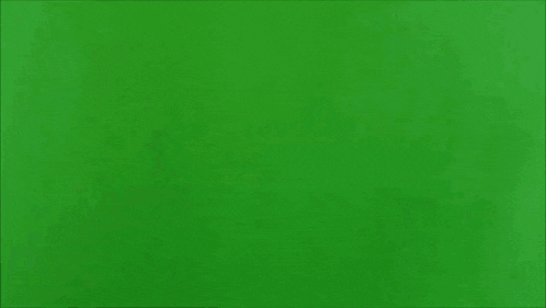 a man is shooting a gun at another man with a green screen in the background .