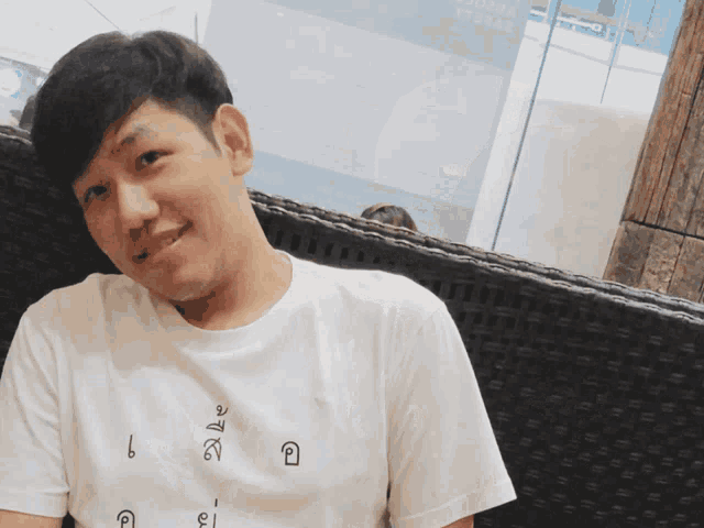 a man wearing a white t-shirt with the letters l and i on it