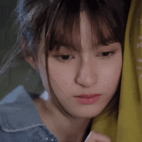 a close up of a woman 's face with a yellow shirt behind her that says cafe on it