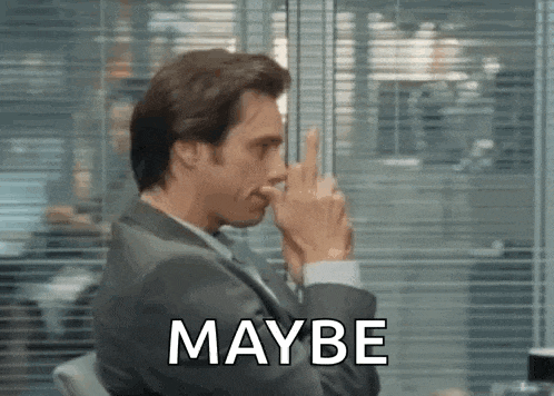 a man in a suit is sitting in front of a window with his finger on his nose and the word maybe .