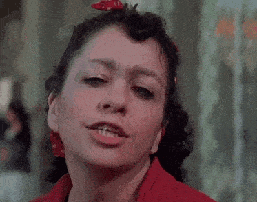 a close up of a woman 's face with a red bandana on her head