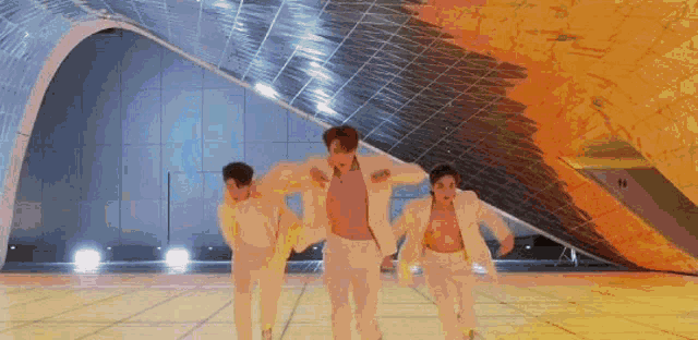 a group of men and women are dancing on a stage in front of a large building .