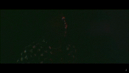 a close up of a person 's face in a dark room with the letter j visible