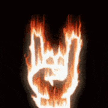 a hand is burning in flames and making a rock and roll sign .