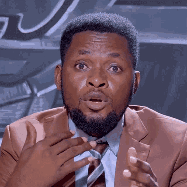 a man with a surprised look on his face wearing a suit and tie