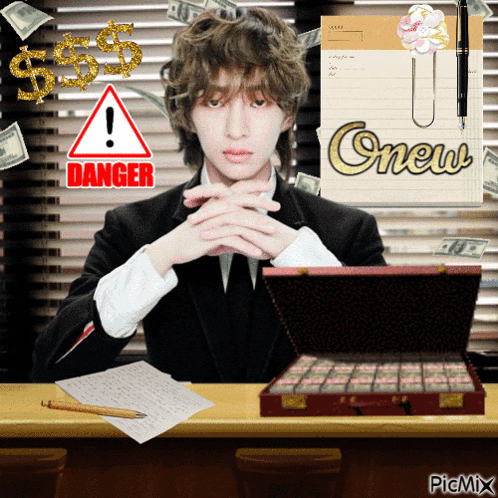 a man in a suit sits at a desk with a briefcase full of money and a sign that says danger on it