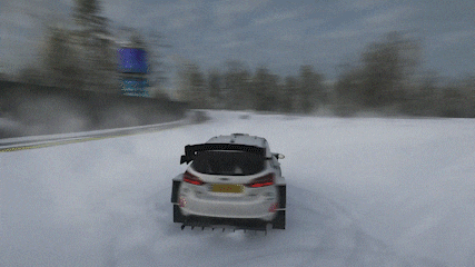 a white ford car is driving on a snowy track