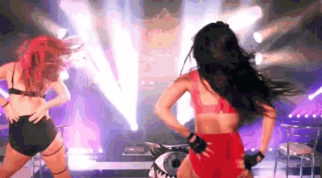 two women are dancing on a stage in front of a shark