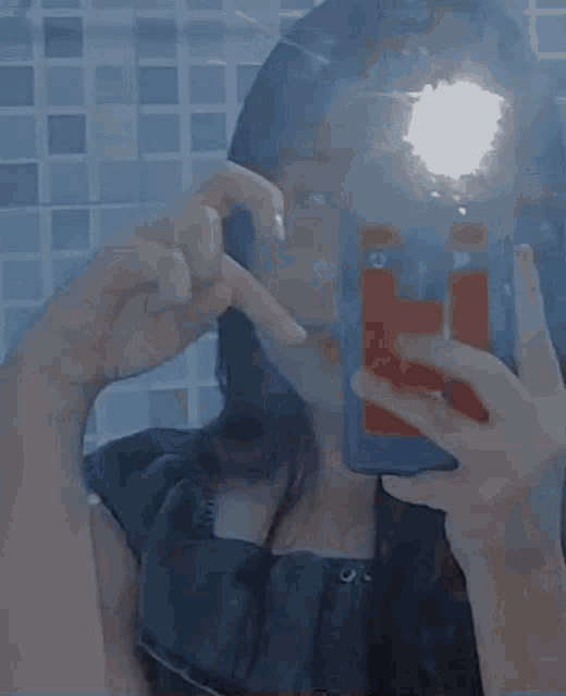 a woman taking a picture of herself in a bathroom mirror