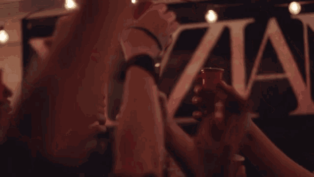 a group of people are toasting with glasses in front of a sign that says ' titan '