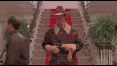 a man wearing a cowboy hat and gloves is standing on stairs .