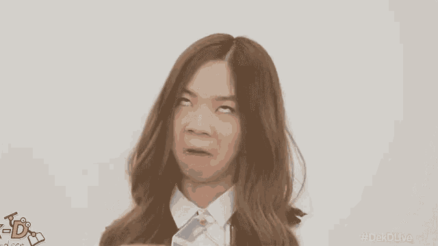 a young girl is making a funny face with her eyes closed and her mouth open .