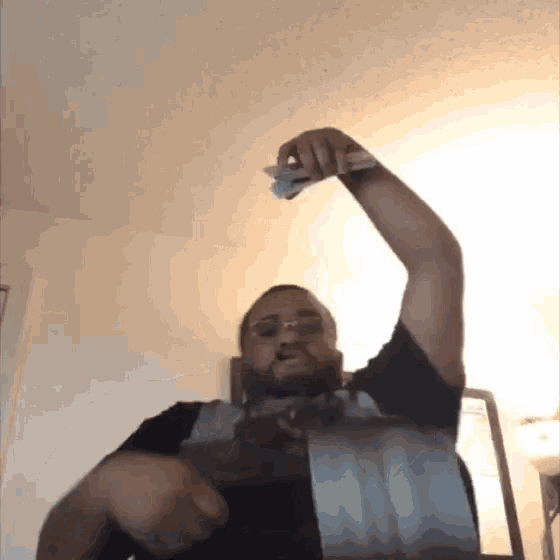 a man in a black shirt is holding a piece of duct tape in his hand