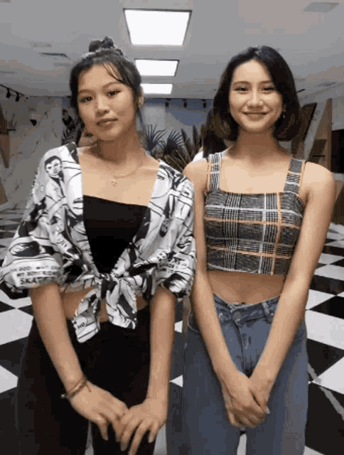 two women standing next to each other with one wearing a crop top that says " i love you "