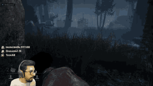 a man with glasses is playing a video game while another man talks to him
