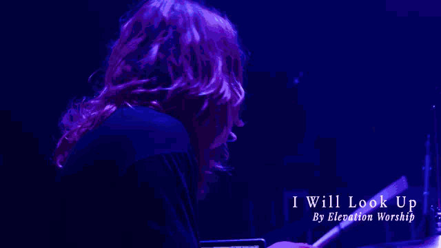 a person is playing a cymbal in a dark room