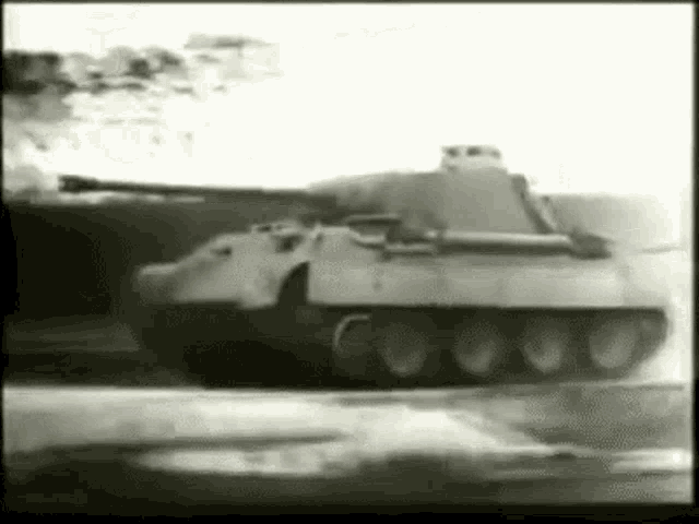 a black and white photo of a military tank driving down a road .
