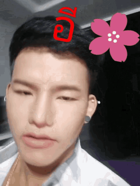 a close up of a man 's face with a pink flower in his hair