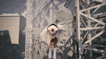 a person wearing a clown costume is standing in front of a metal structure