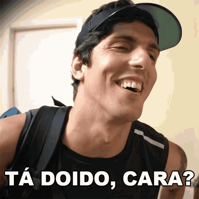 a man wearing a hat is smiling with the words ta doido cara written below him
