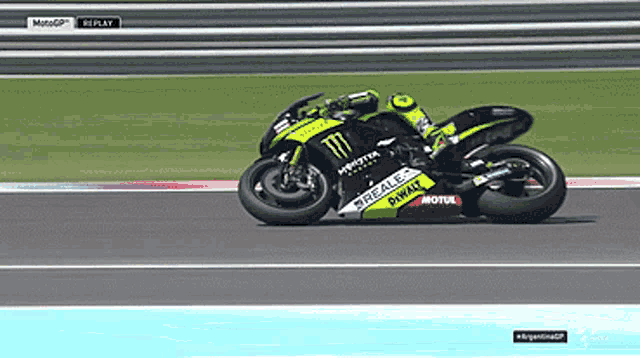 a man riding a monster energy motorcycle on a racetrack
