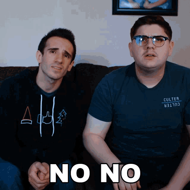 two men are sitting on a couch and one of them is wearing a shirt that says culter on it