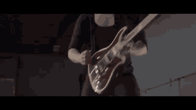 a man is playing a red guitar in a dark room .