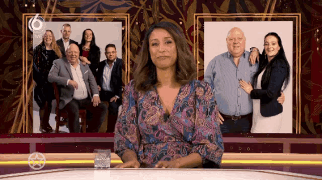 a woman stands in front of a picture of a family with the number 6 on the bottom