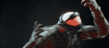 a man wearing a gas mask and gloves is waving his hand