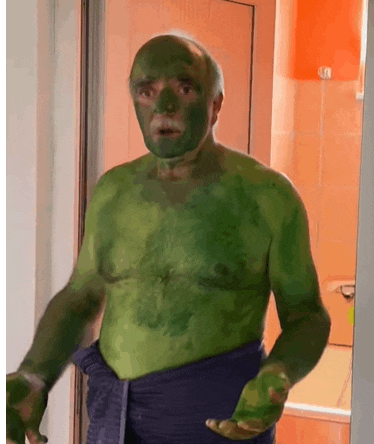 a shirtless man with green paint on his face and body