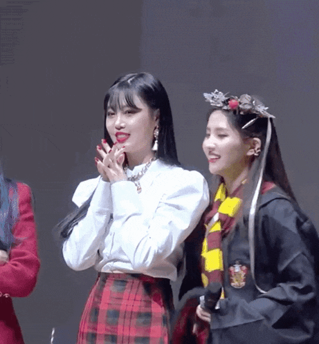 a girl in a harry potter costume is standing next to another girl