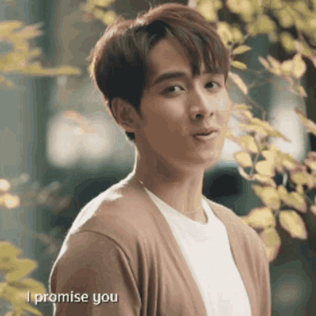 a young man is wearing a brown cardigan and a white shirt and says i promise you