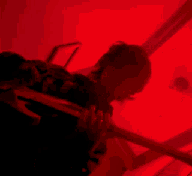 a person in a dark room with a red light behind