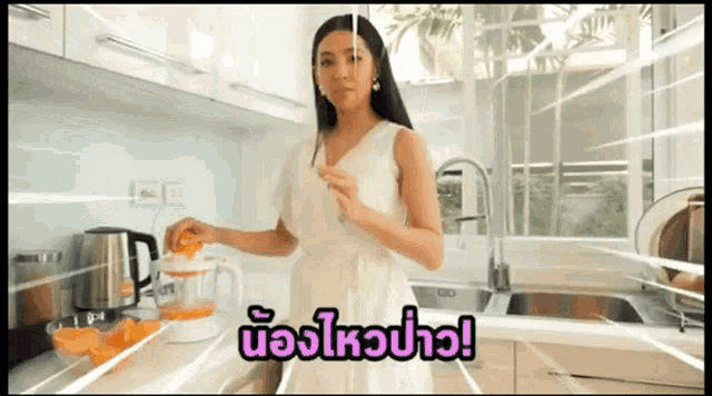 a woman in a white dress is using a blender in a kitchen