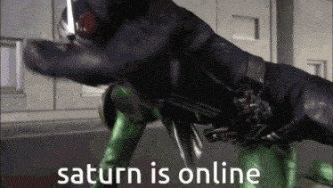 a man in a black suit is fighting another man in a green suit with the words saturn is online below him