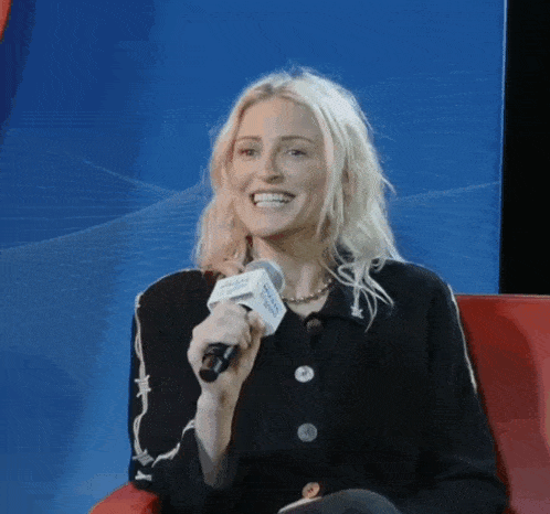 a woman is smiling while holding a microphone that says ' pacific northwest ' on it